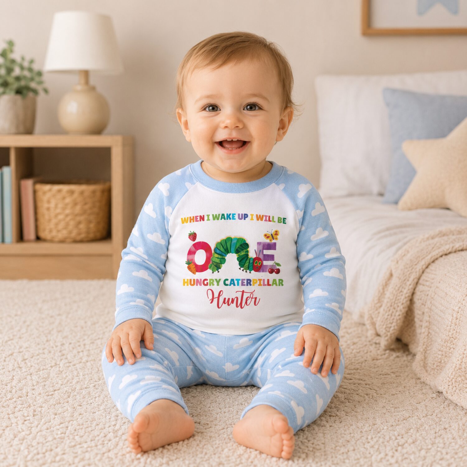 Toddler wearing personalised Hungry Caterpillar first birthday pyjamas in bedroom lifestyle photo
