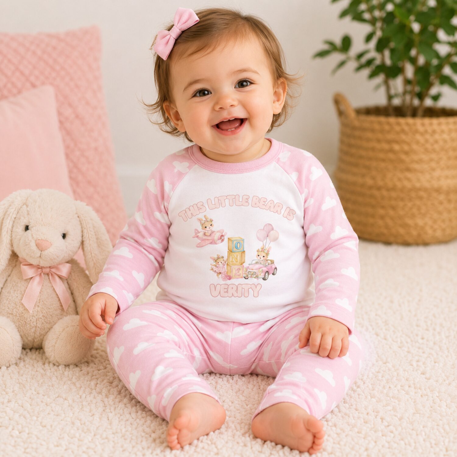 Toddler girl wearing personalised pink teddy bear first birthday pyjamas in lifestyle photo