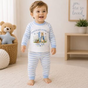 Toddler wearing personalised Peter Rabbit inspired first birthday pyjamas with custom name and age.