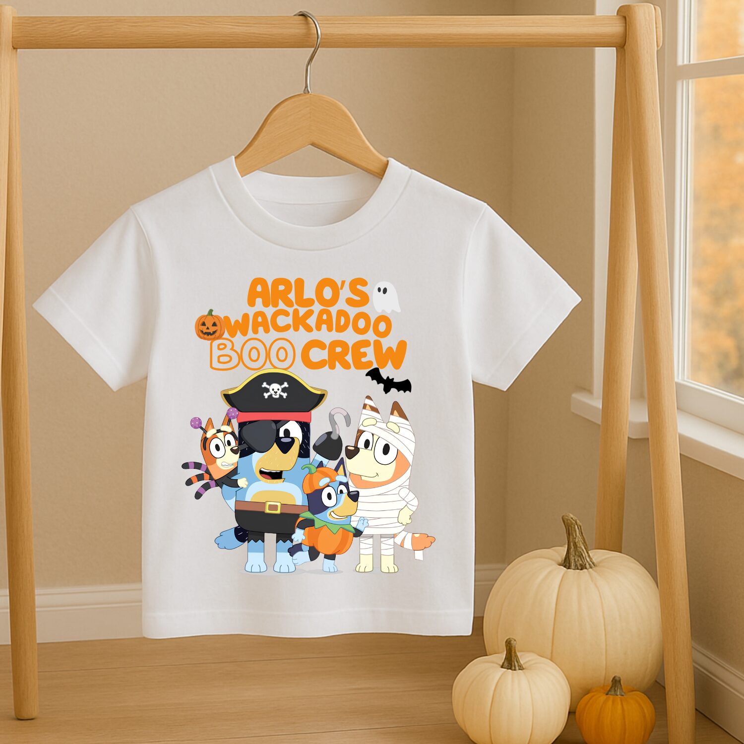 Personalised Bluey and Bingo Halloween Boo Crew T-shirt hanging beside pumpkins