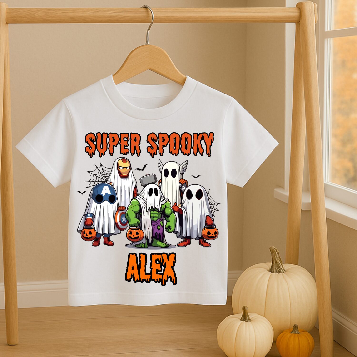Personalised superhero Halloween kids T-shirt hanging beside autumn pumpkins