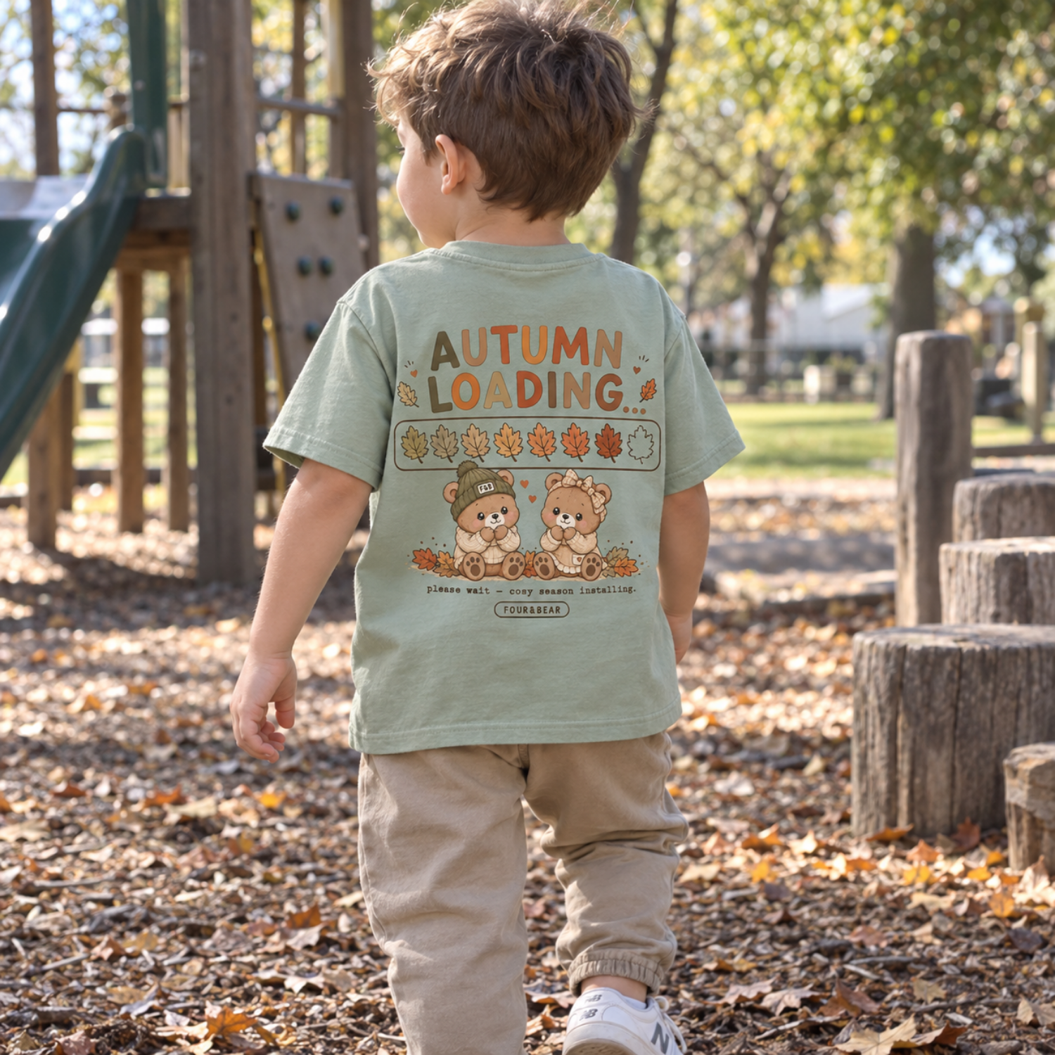 kids autumn loading sage tshirt lifestyle.png Child wearing a white Four & Bear autumn sweatshirt with small chest print at the park