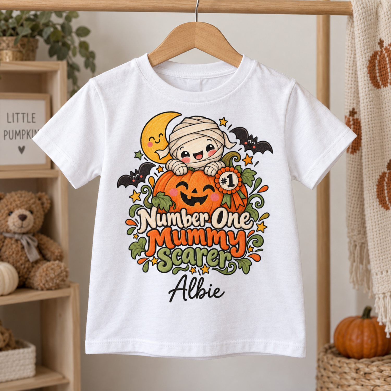 personalised kids halloween tshirt first halloween outfit White personalised first Halloween T-shirt with cute mummy and pumpkin design on wooden hanger