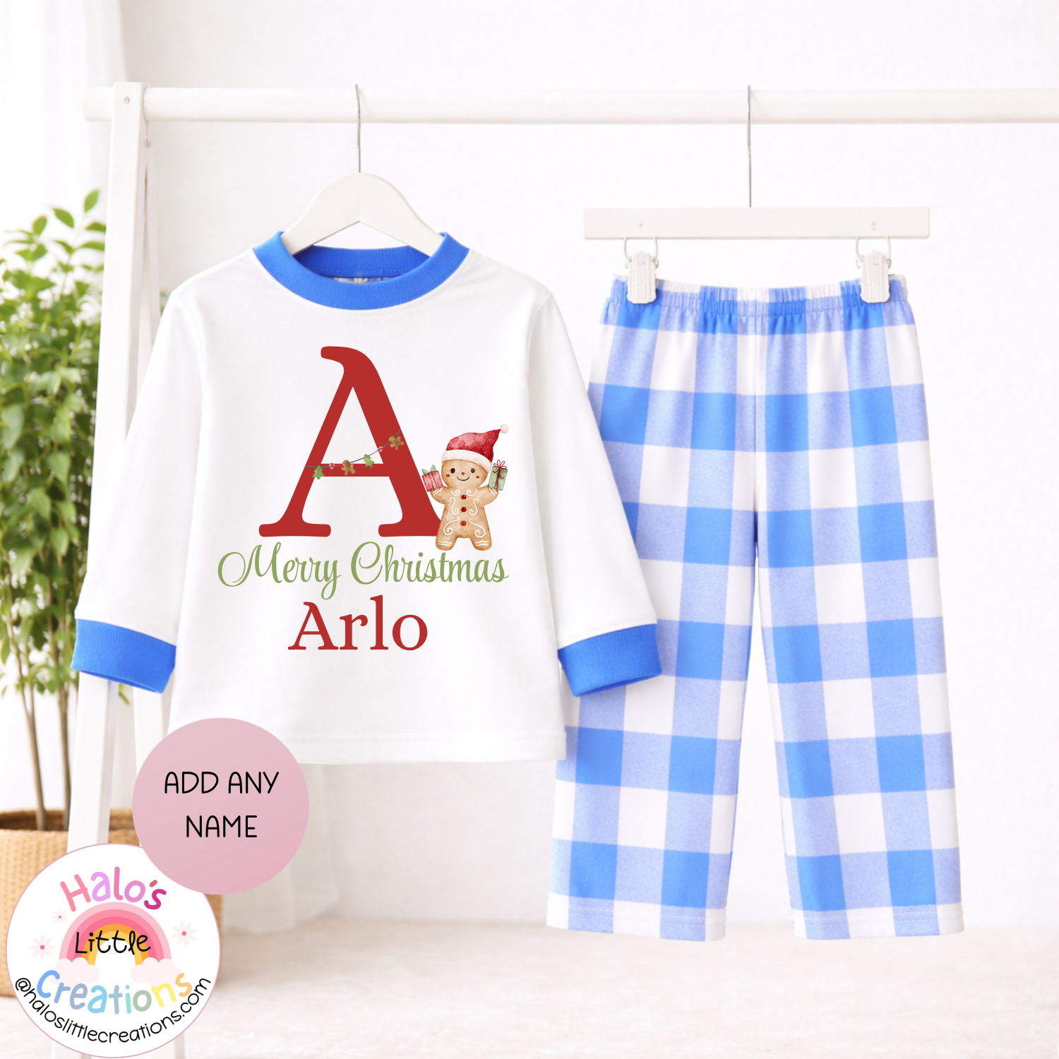 Personalised Christmas pyjama set with blue and white checked trousers, white top with blue trim and festive initial and name Arlo.