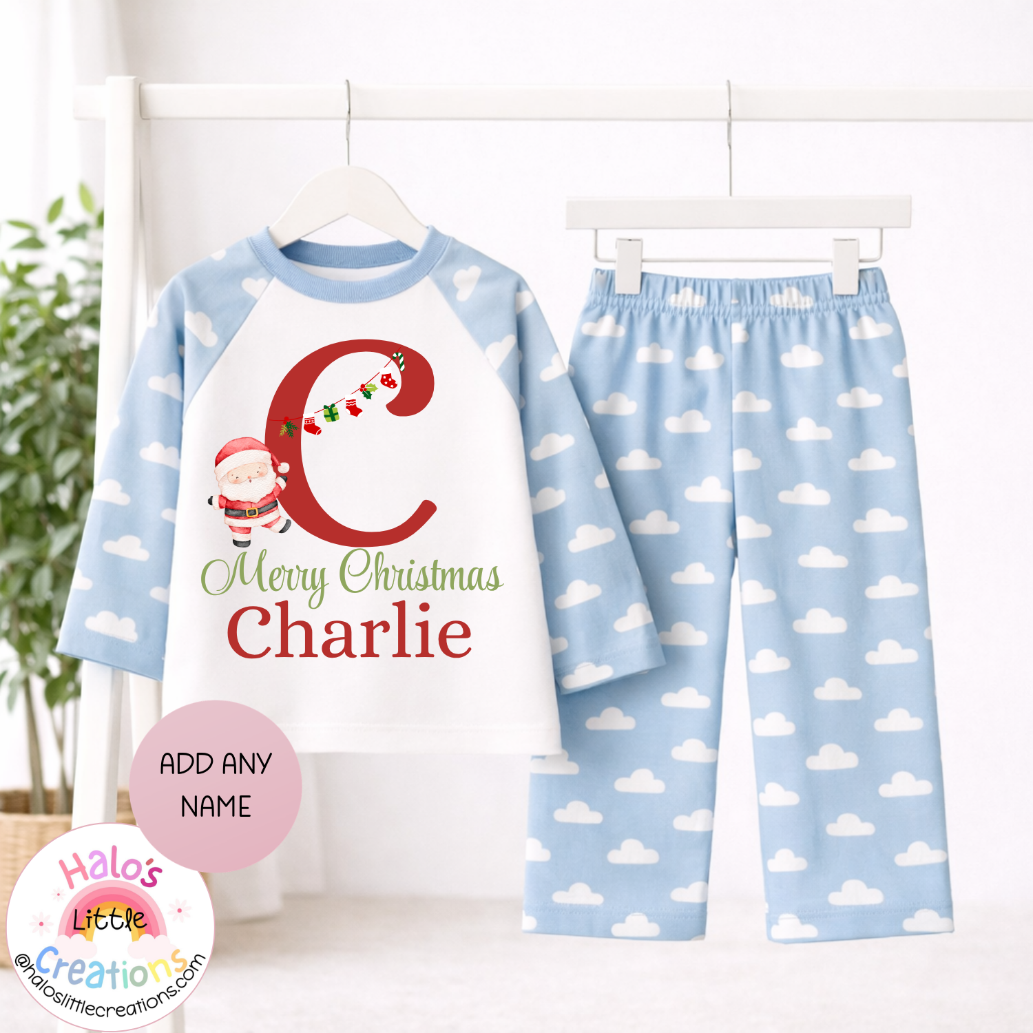 Personalised children's Christmas pyjamas with blue cloud print sleeves and trousers, red festive initial, Santa illustration and name Charlie.